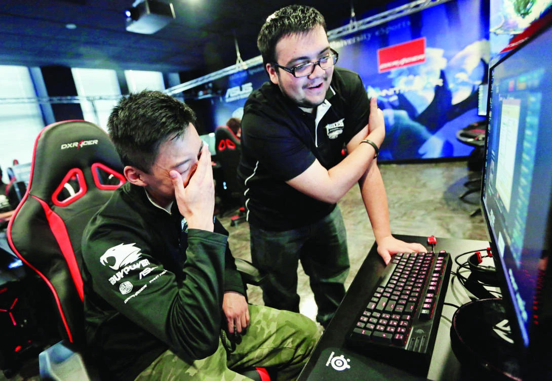 Robert Morris University Illinois freshman Alex Chapman, left, is critiqued by assistant coach Jose Carrasco as he practices playing the video game “League of Legends” with their collegiate teammates at their on-campus training facility in Chicago. (AP)