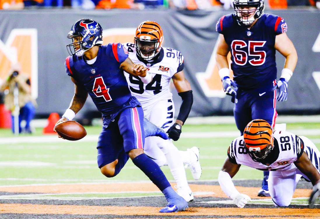 Houston Texans quarterback Deshaun Watson, left, breaks away from Cincinnati Bengals defensive end Chris Smith (94) and linebacker Carl Lawson (58) to score a touchdown during the first half of an NFL football game, in Cincinnati on Thursday. (AP)