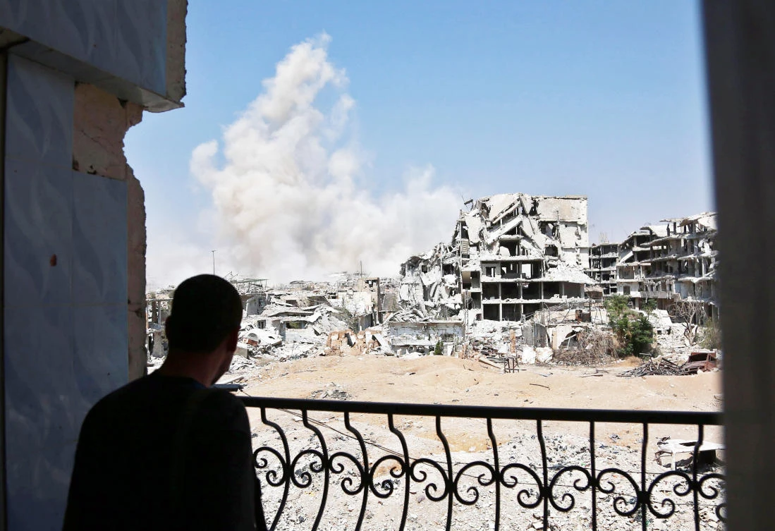 A man looks at smoke rising from buildings following a strike on an opposition-held area of the Jobar district, east of Damascus. (AFP)
