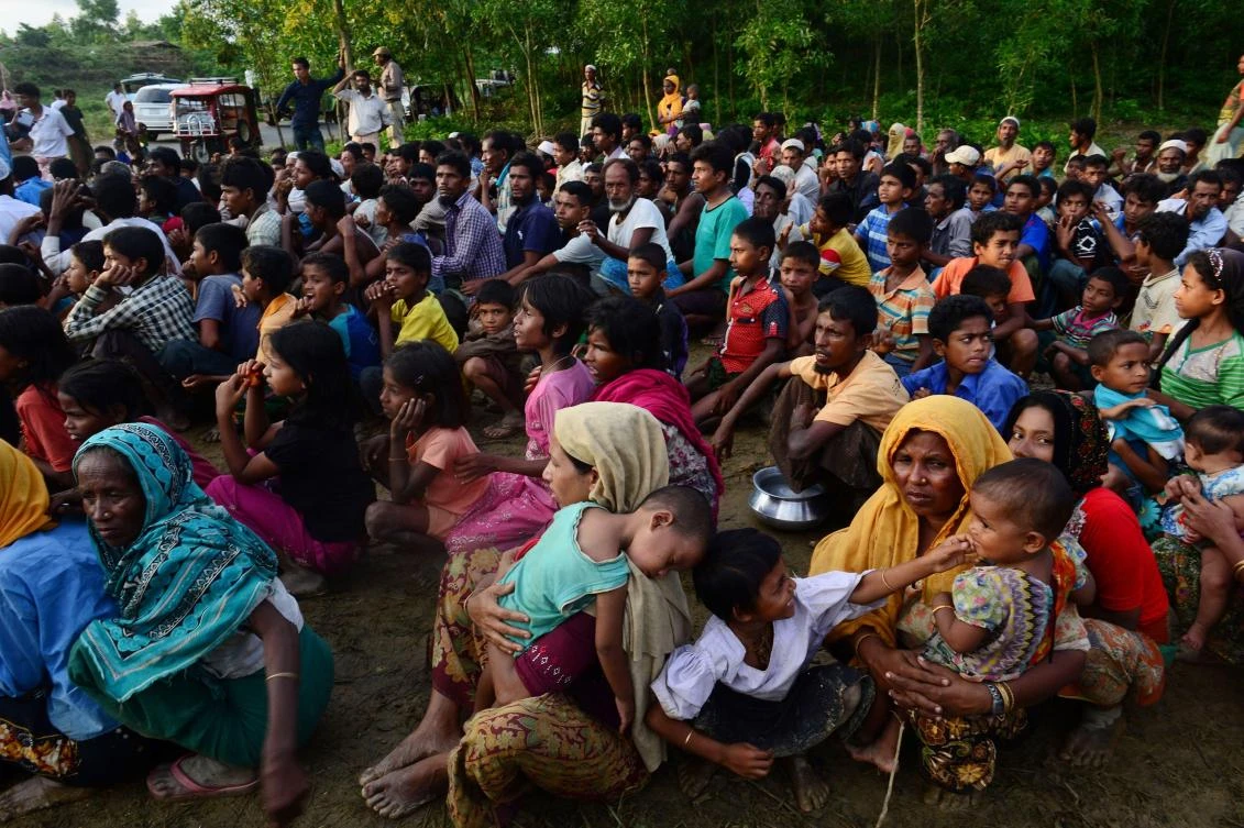 Rohingya people wait for relief supplies near a refugee camp in Kutupalong in the Bangladeshi district of Ukhia on September 8, 2017. Some 270,000 refugees have fled Myanmar's violence-wracked Rakhine state and entered Bangladesh in the last fortnight, most from the Muslim Rohingya minority, the United Nations said on September 8. / AFP / Munir UZ ZAMAN