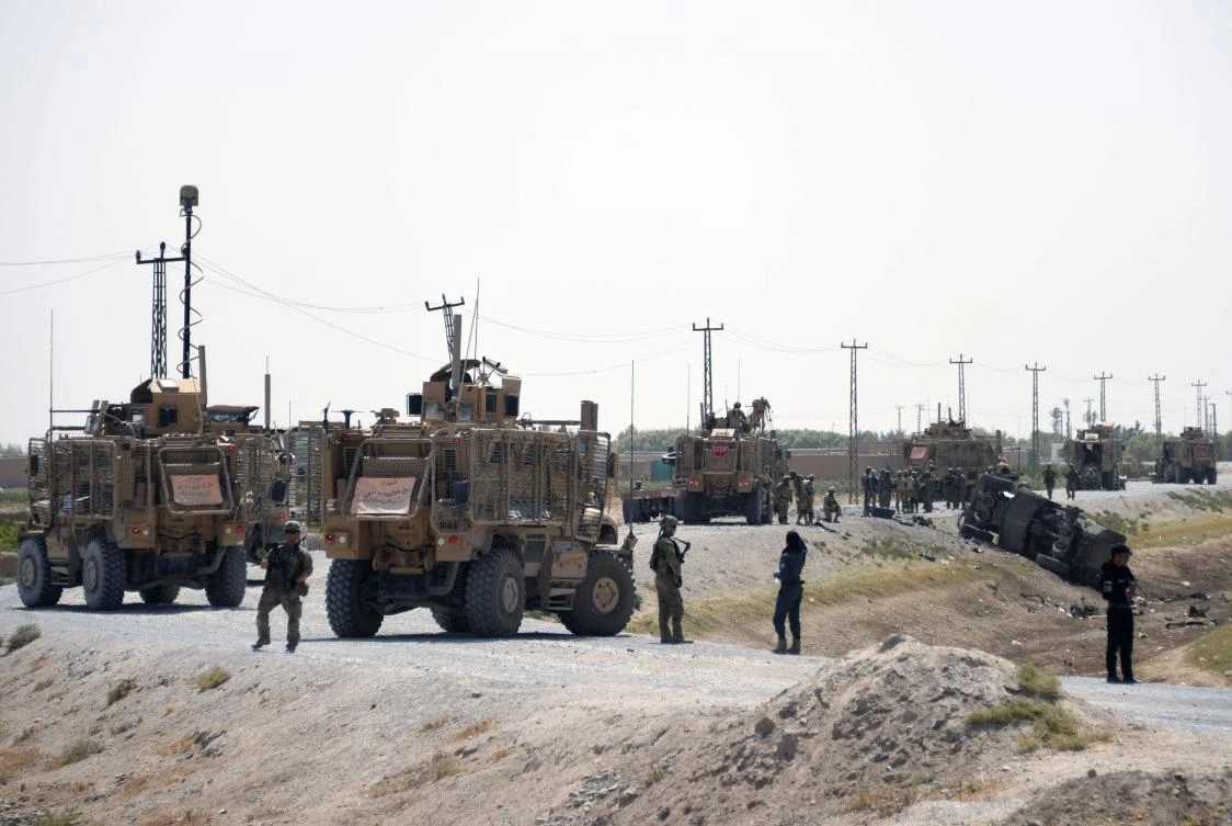 NATO soldiers keep watch near the wreckage of their vehicle at the site of a Taliban suicide attack in Kandahar. (AFP)