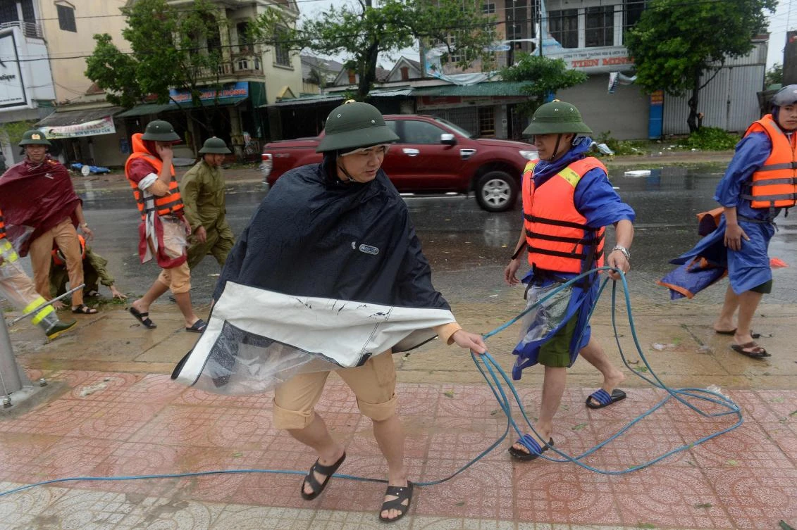 Police remove electrical cables as they clear a street in Ky Anh town in the central province of Ha Tinh, as Typhoon Doksuri makes landfall, on September 15, 2017. Heavy rain and wind lashed Vietnam's central coast on September 15 as Typhoon Doksuri made landfall, prompting mass evacuations as officials predicted it could be the most powerful storm in a decade. (AFP)