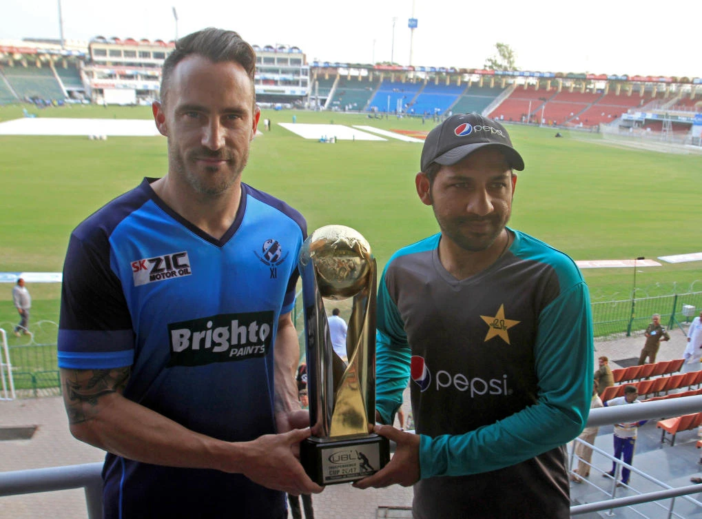 Team captain Sarfraz Ahmed of Pakistan and International World XI captain Faf du Plessis hold the Independence Cup trophy at the Qaddafi Cricket Stadium in Lahore, Pakistan, on September 11, 2017. (File photo by Reuters)