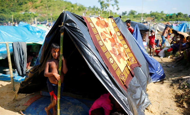 A Rohingya refugee boy looks on as he stands in his makeshift tent in Cox’s Bazar on Saturday. (Reuters)