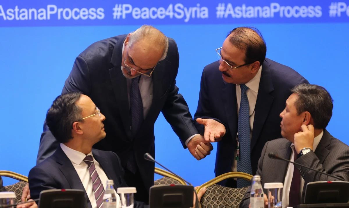Syrian chief negotiator and Ambassador of the Permanent Representative Mission of Syria to the United Nations Bashar Al-Jaafari (2L) and Syrian ambassador to Russia Riad Haddad (2R) speak with unidentified Kazakh officials during the session of Syria peace talks in Astana. (AFP)