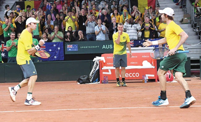 Australia’s captain Lleyton Hewitt, center, and players Jordan Thompson, right, and John Peers celebrate after winning the Davis Cup semi final between Belgium and Australia in Brussels on Saturday. (AFP)