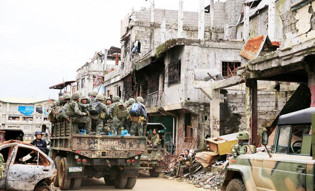 A military truck full of government soldiers move past damaged houses and buildings as troops continue their assault on clearing operations against the pro-Daesh militant group which seized Mapandi district in Marawi city, southern Philippines, in this September 13, 2017 photo. (REUTERS)
