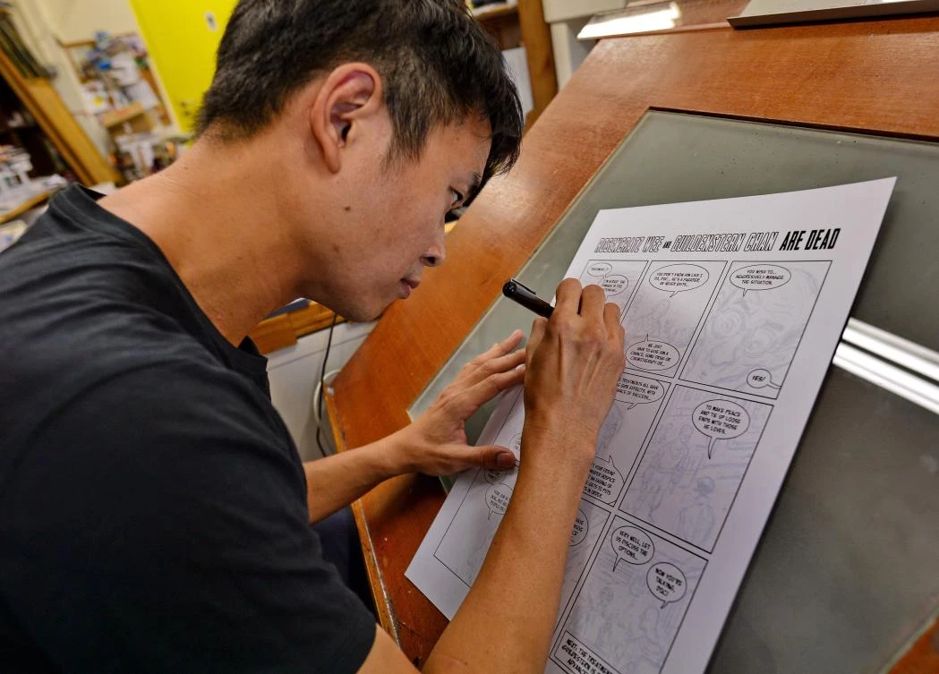 This photograph taken on August 3, 2017 shows Singaporean cartoonist Sonny Liew sketching at his office in Singapore. Singapore cartoonist Sonny Liew swept the comic industry's "Oscars" and is a hit at home, but the city-state has struggled with how to respond to his surprise best seller that challenges its own carefully-scripted version of history. - To go with AFP story Singapore-arts-cartoon-history, by Elizabeth Law -- RESTRICTED TO EDITORIAL USE - MANDATORY MENTION OF THE ARTIST UPON PUBLICATION - TO ILLUSTRATE THE EVENT AS SPECIFIED IN THE CAPTION / AFP / ROSLAN RAHMAN / To go with AFP story Singapore-arts-cartoon-history, by Elizabeth Law -- RESTRICTED TO EDITORIAL USE - MANDATORY MENTION OF THE ARTIST UPON PUBLICATION - TO ILLUSTRATE THE EVENT AS SPECIFIED IN THE CAPTION