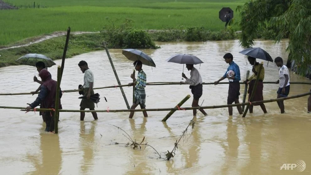 Rohingya Muslim refugees cross floodwater in Thyangkhali refugee camp near the Bangladesh town of Ukhia. (AFP)