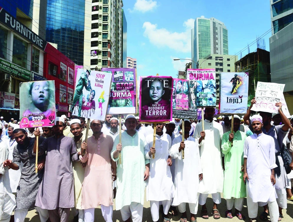 Protesters hold placards and shout slogans during a rally to protest the prosecution of Rohingya Muslims in Myanmar, in Dhaka on Monday. (AFP)