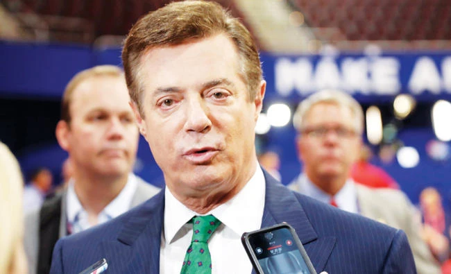 In this July 17, 2016 file photo, Trump Campaign Chairman Paul Manafort talks to reporters on the floor of the Republican National Convention at Quicken Loans Arena in Cleveland as Rick Gates listens at back left. (AP)