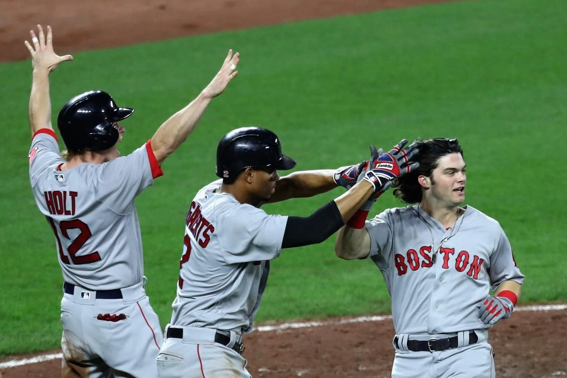 Brock Holt #12, Xander Bogaerts #2, and Andrew Benintendi #16 of the Boston Red Sox celebrate after scoring against the Baltimore Orioles in the fifth. (Getty Images/AFP)