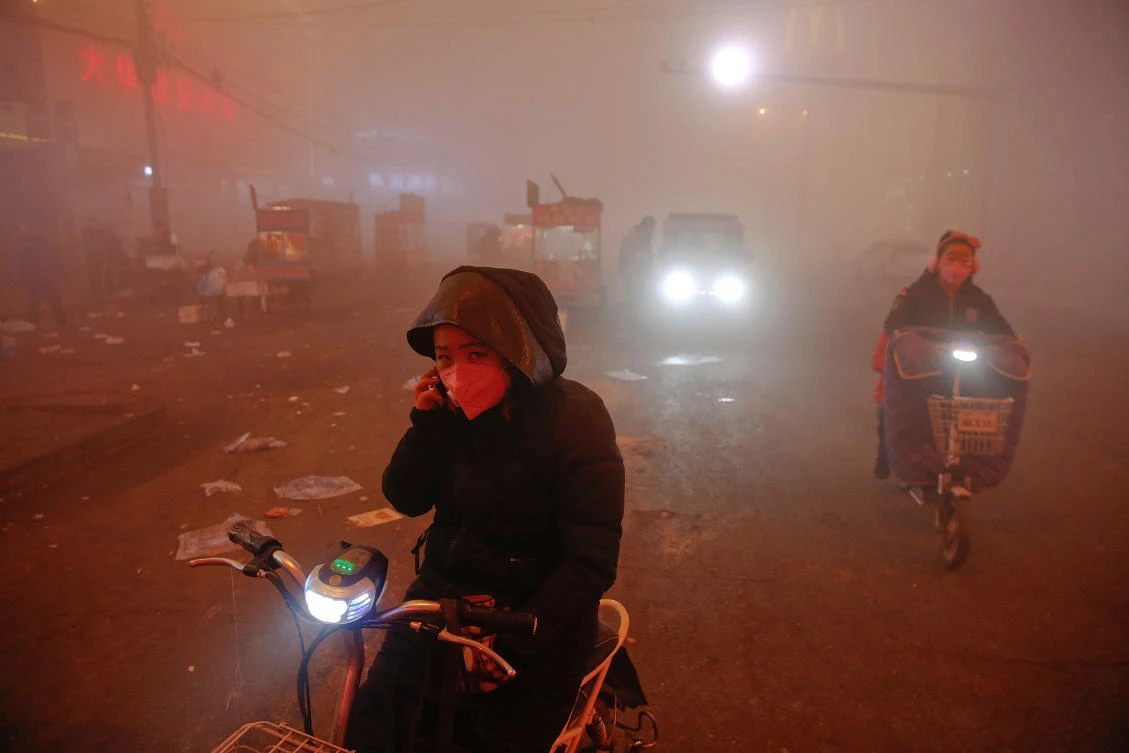 File photo: People make their way through heavy smog on an extremely polluted day with red alert issued, in Shengfang, Hebei province, China. (Reuters)