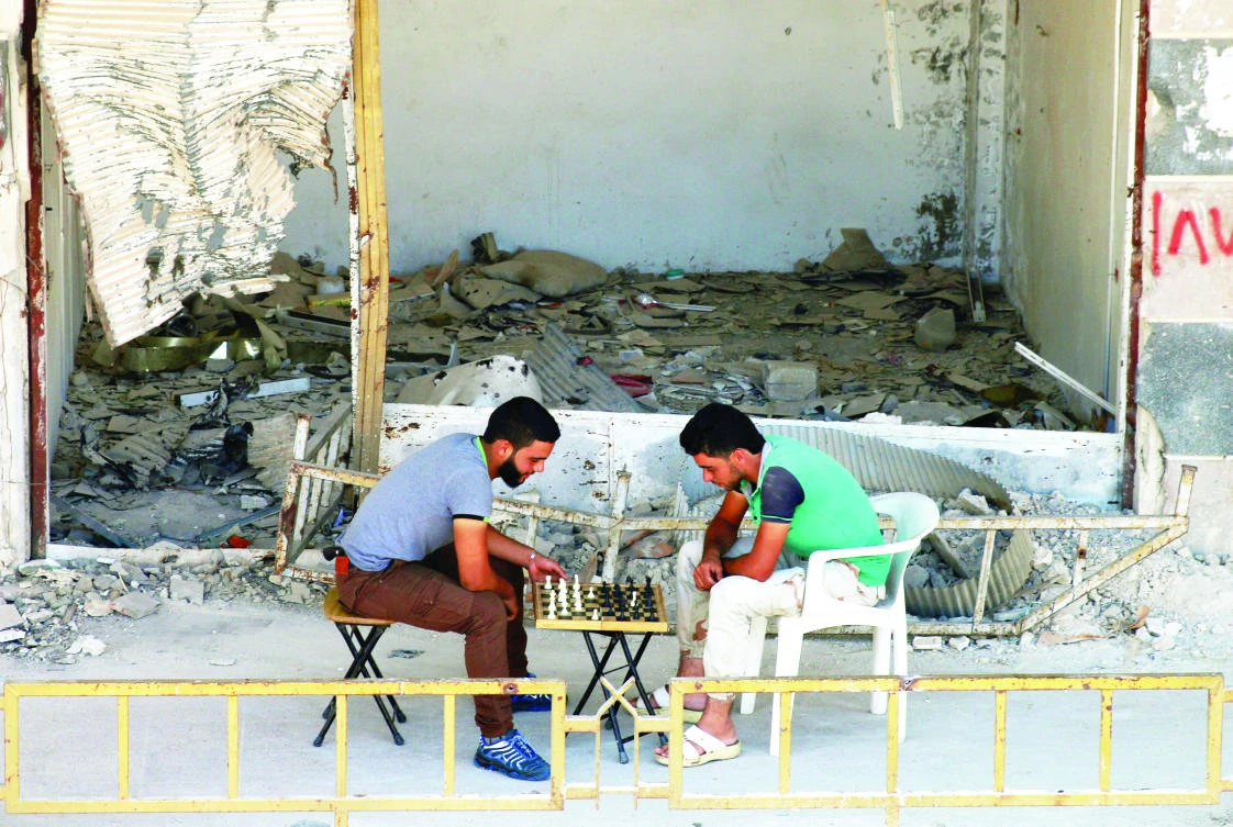People play chess on Tuesday in the southern town of Bosra Al-Sham, Deraa Governorate, Syria. (Reuters)