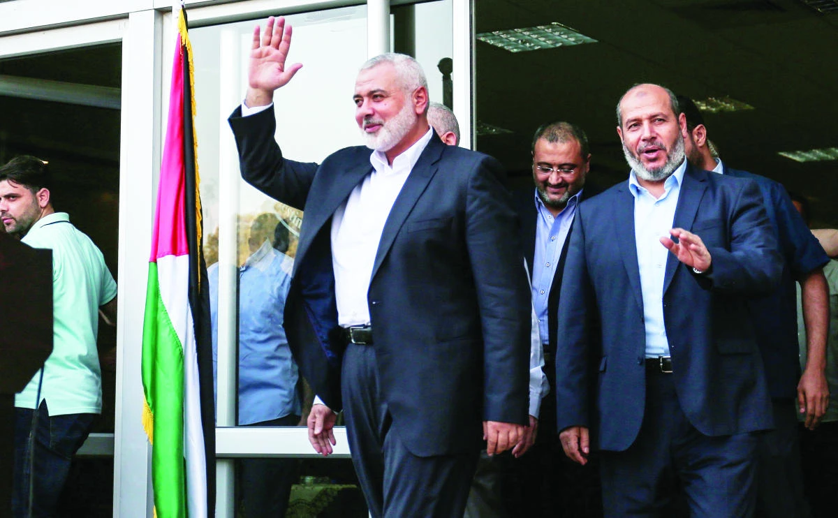 Ismail Haniyeh, Hamas chief, waves to journalists upon his arrival on the Palestinian side of the Rafah border crossing, in the southern Gaza Strip on Thursday. (AFP)