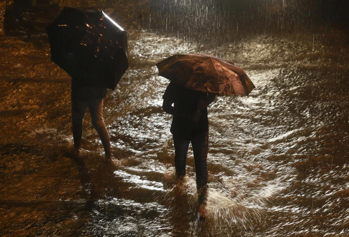 People walk past a waterlogged street in the rain in Mumbai, India, Tuesday, Sept. 19, 2017. Monsoon season in India begins in June and ends in October. (AP Photo/Rafiq Maqbool)
