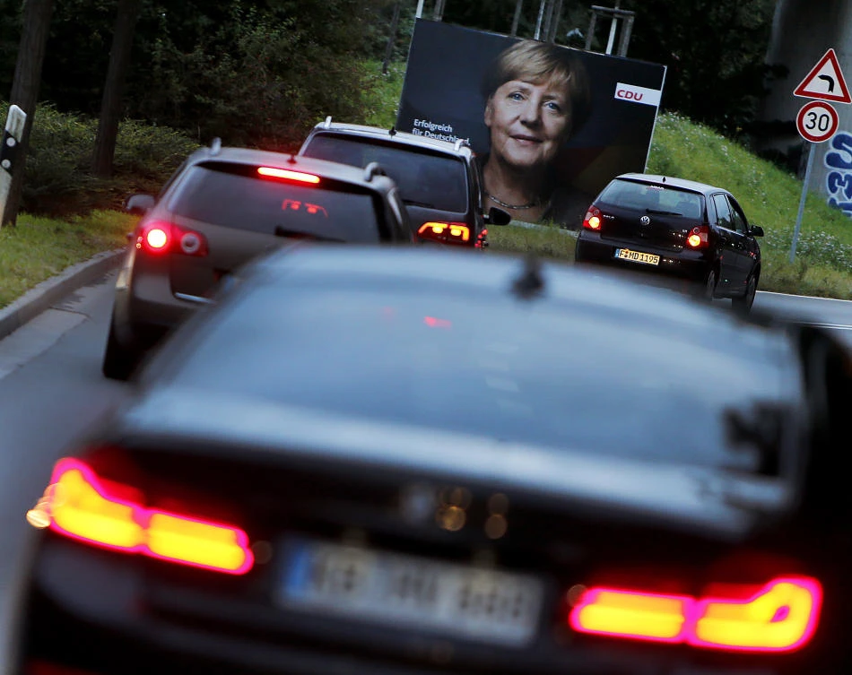 Cars pass an election poster showing German Chancellor Angela Merkel in Frankfurt, Germany. (AP)