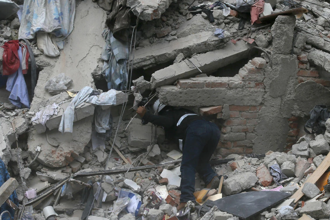 A construction worker searches a building that collapsed after an earthquake, in the Roma neighborhood of Mexico City, Tuesday, Sept. 19, 2017. A magnitude 7.1 earthquake has rocked central Mexico, killing at least 55 people as buildings collapsed in plumes of dust and thousands fled into the streets in panic. (AP)