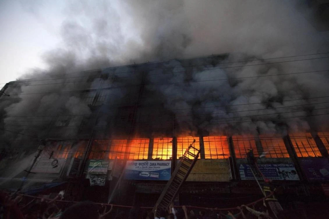 Locals and fire-fighters try to control a fire at a garment factory in Dhaka on March 6, 2014. (File photo by Reuters)