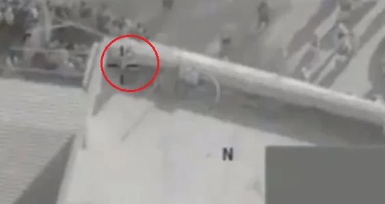 In its sights, a Daesh sniper is seen (circled) on the roof of a building (MOD)