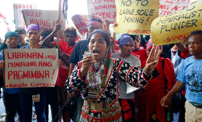 An indigenous person addresses supporters after rushing closer to the venue of a mining conference to protest alleged incursion of big mining companies into their ancestral lands in Manila on Sept. 6. (AP)