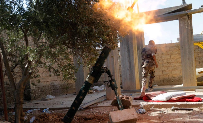 In this July 27, 2017 file photo, a U.S.-backed Syrian Democratic Forces fighter, runs as he fires mortars at Daesh group militant in Raqqa, northeast Syria. The Syrian Democratic Forces said in a statement on Wednesday, that the battle for the Daesh group's de-facto capital, Raqqa, has reached its "final stages" with the opening of a new front. (AP)
