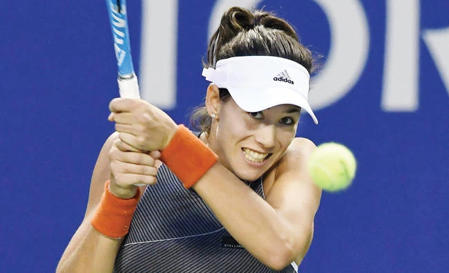Garbine Muguruza of Spain hits a return against Monica Puig of Puerto Rico during their women’s singles second round match at the Pan Pacific Open tennis tournament in Tokyo on Wednesday. (AFP)