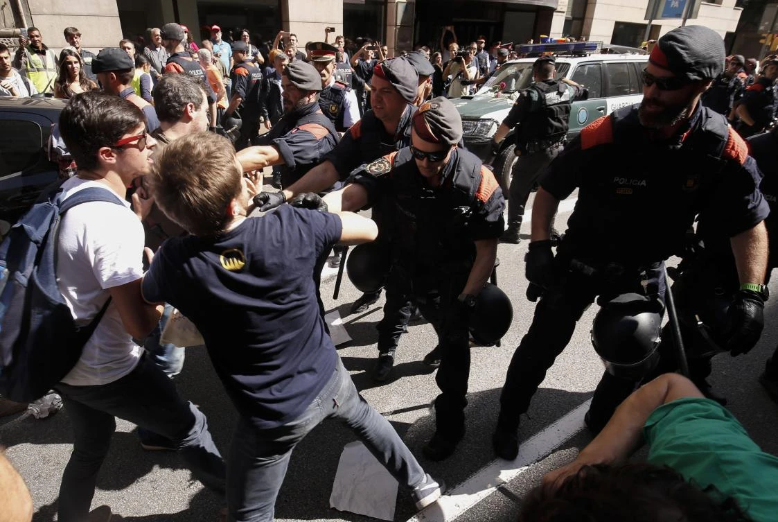 Catalan regional police officers 'Mossos D'Esquadra' try to disperse protesters in front of the headquarters of Catalonia's regional foreign affairs ministry in Barcelona on September 20, 2017. (AFP / PAU BARRENA)