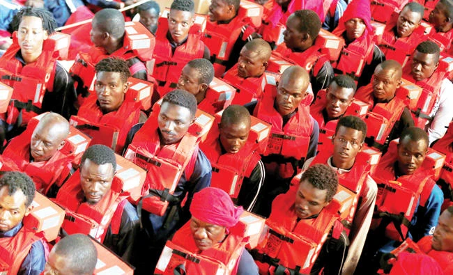 File photo shows migrants standing in line as they wait to be transferred to Spanish frigate Canarias after being rescued by “Save the Children” NGO crew in the Mediterranean sea off Libya coast. (Reuters)