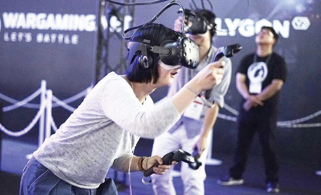 Visitors try out a game with a virtual reality headset device at the Tokyo Game Show in Chiba. (AP)
