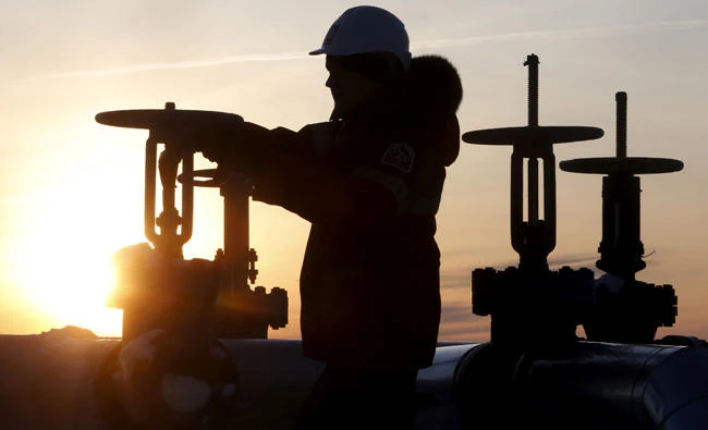 A worker checks the valve of an oil pipe at the Lukoil company owned Imilorskoye oil field outside the Siberian city of Kogalym, Russia. (Reuters file)