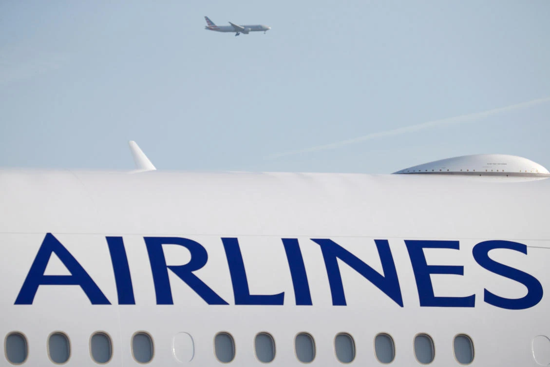 Above, an aircraft flies over a Boeing 777-300ER airplane of China Airlines during the 51st Paris Air Show at Le Bourget airport near Paris. (Reuters)