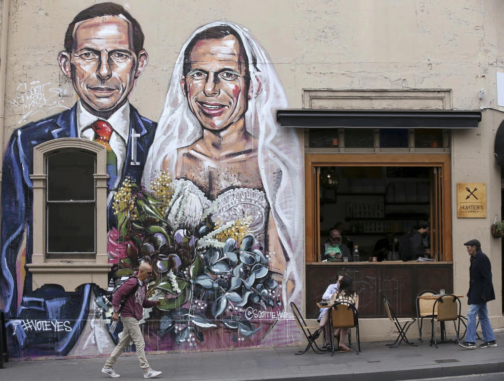 A mural depicting former Australian Prime Minister Tony Abbott during a wedding ceremony where he is both the groom and bride is displayed on a cafe wall in Sydney. (AP)