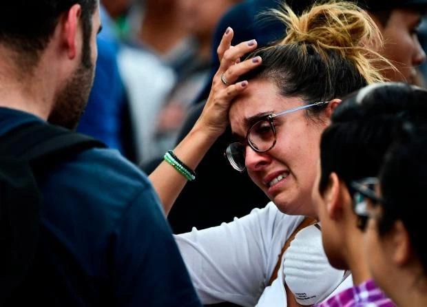 A woman with a relative possibly buried under the rubble of a building knocked down by the earthquake awaits news from rescue teams in Mexico City. (AFP)