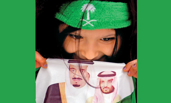 A Saudi girl presents a shirt bearing a photo of King Salman and Crown Prince Mohammed bin Salman during celebrations marking the 87th Saudi Arabian National Day in Jeddah on Friday. (AN photo by Khaled Khamis)