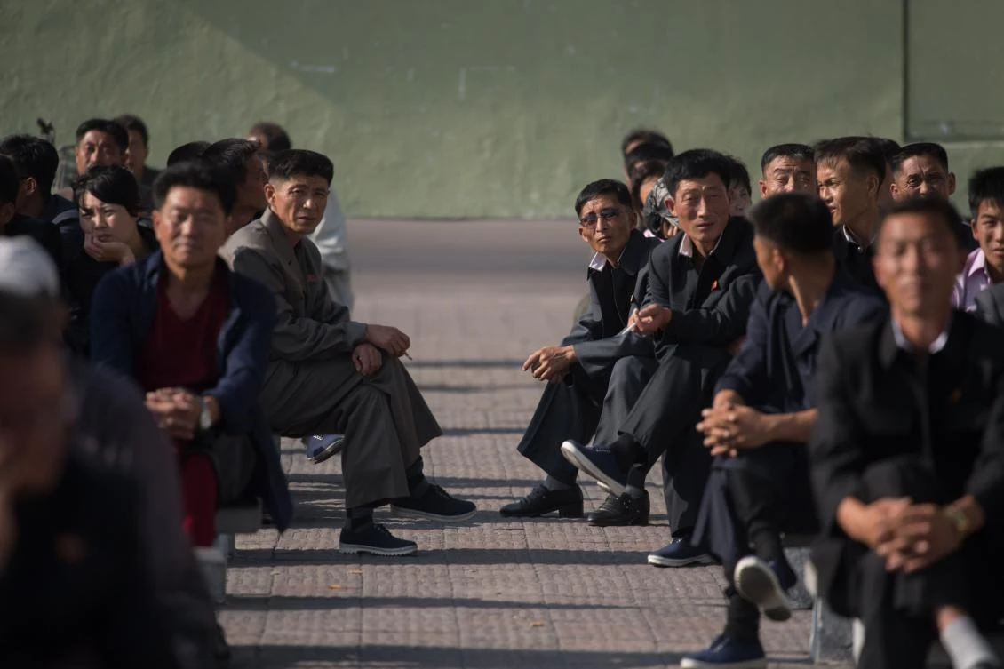 Residents gather to watch a public news broadcast of a statement by North Korean leader Kim Jong-Un, before a public television screen outside the central railway station in Pyongyang. (AFP)