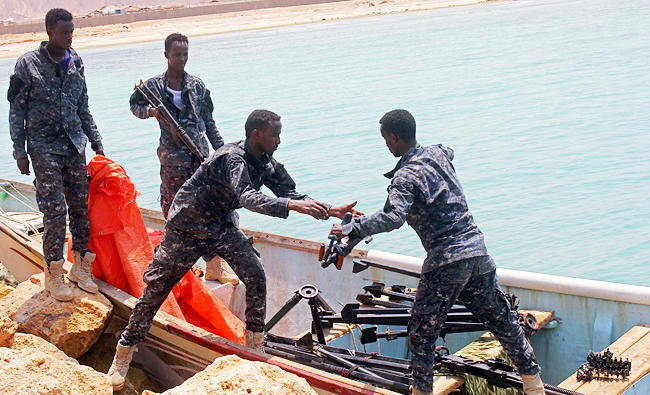Somali Puntland forces receive weapons seized from a boat on the shores of the Gulf of Aden in Bosasso, Puntland region, Somalia. Available evidence does not establish that the groups are jointly selecting vessels to attack or coordinating a sustained maritime offensive. (Reuters file)