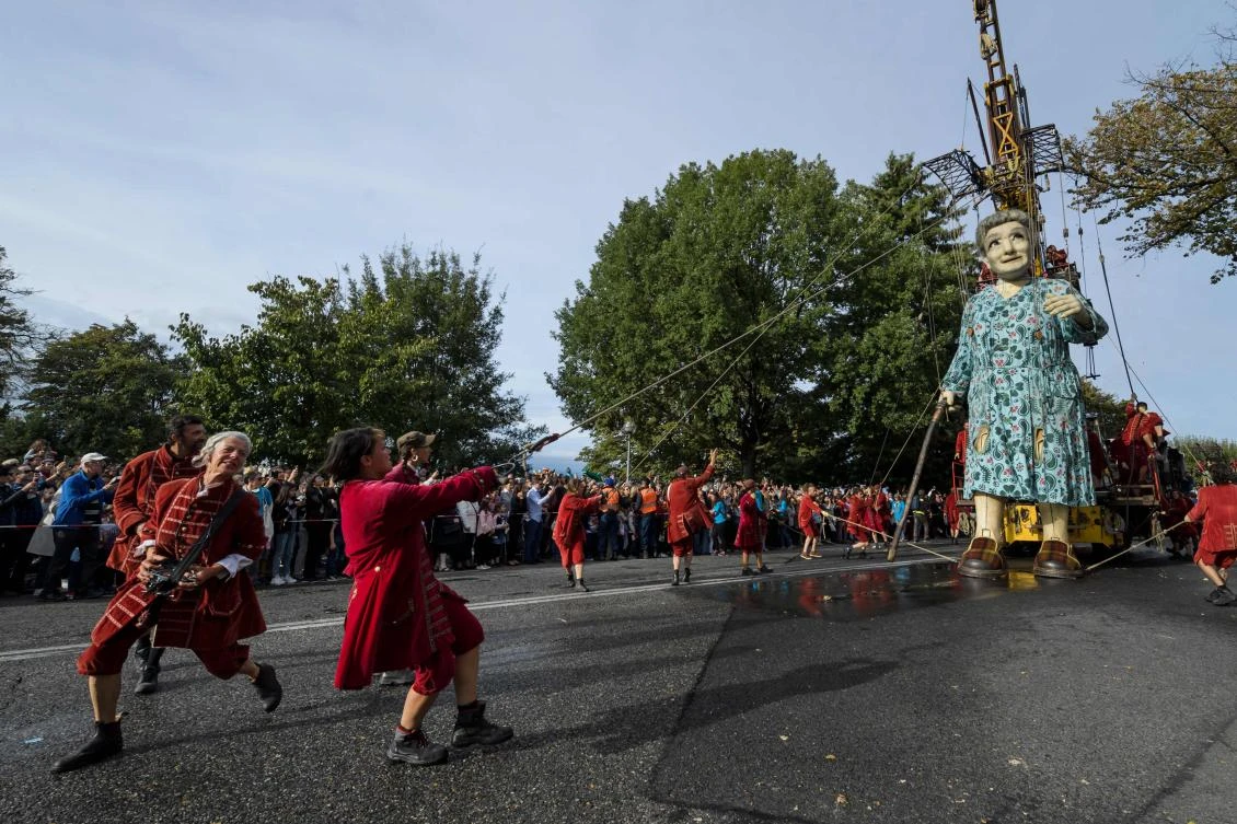 A 7,30 meters high giant animated puppet representing a grandmother created by French street theatre company Royal de Luxe, makes her way during the last act of 'The Saga of the Giants' a three days street performance gathering hundred thousand spectators, on October 1 2017 in Geneva. - / AFP / Fabrice COFFRINI