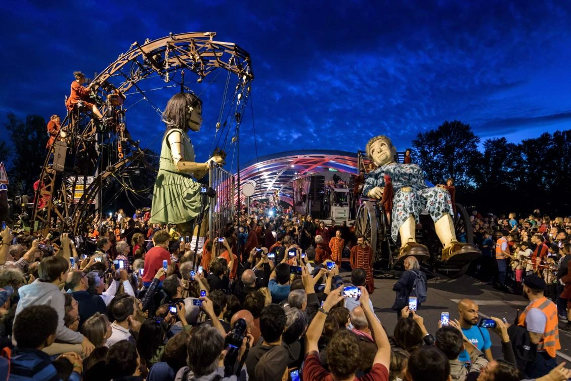 Animated marionettes called 'The Little Girl Giant' and 'The Grandmother Giant' by French street theatre company Royal de Luxe parade through the streets of Carouge during their 'The Saga of the Giants' performance on September 29, 2017 in Geneva. The Royal de Luxe Company are to perform in Geneva until October 1, 2017. - / AFP / Fabrice COFFRINI