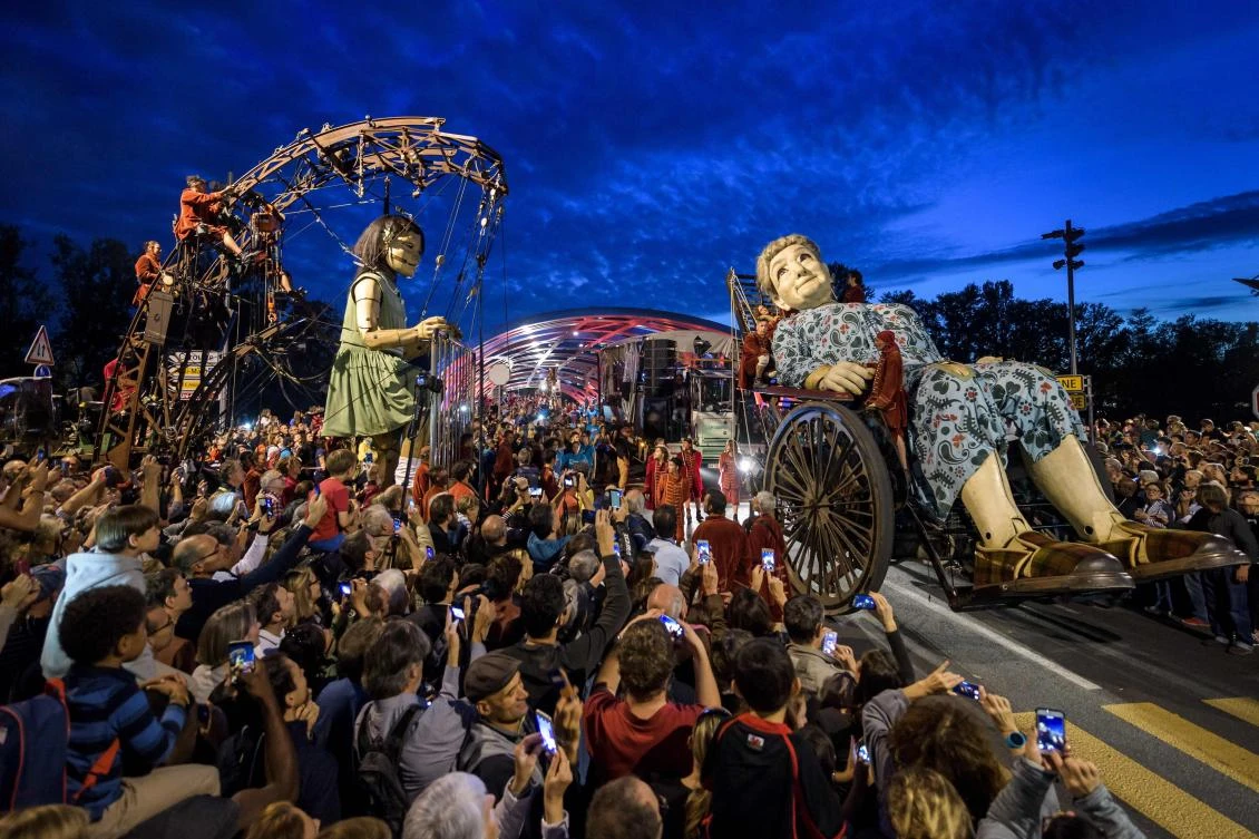 Animated marionettes called 'The Little Girl Giant' and 'The Grandmother Giant' by French street theatre company Royal de Luxe parade through the streets of Carouge during their 'The Saga of the Giants' performance on September 29, 2017 in Geneva. The Royal de Luxe Company are to perform in Geneva until October 1, 2017. - / AFP / Fabrice COFFRINI
