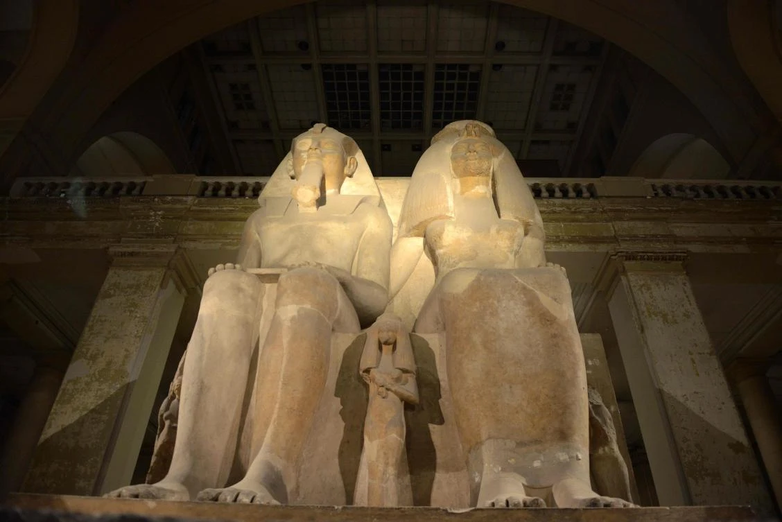 A picture taken on October 28, 2017, shows a limestone sculpture of Egyptian Pharaoh Amenhotep III, the ninth pharaoh of the Eighteenth Dynasty, with his wife Tiye, and their three daughters on display at the Egyptian Museum during the "Night of Art" exhibit in the capital Cairo. / AFP / MOHAMED EL-SHAHED