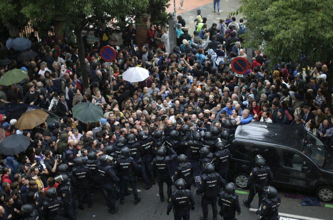 Spanish National Police prevents people from entering a voting site at a school assigned to be a polling station by the Catalan government in Barcelona, Spain, Sunday, October 1, 2017. (AP Photo)