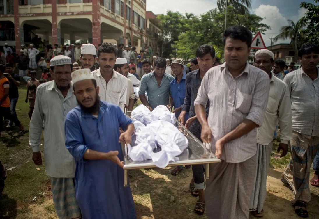 Bangladeshi men carry the bodies of a Rohingya Muslim refugee at a school near Inani beach in Cox’s Bazar district on September 29, 2017. (File photo by AFP)