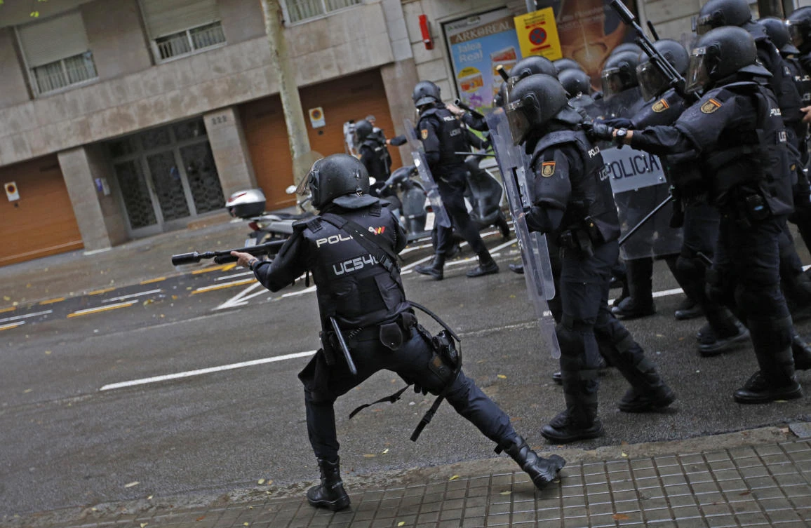 Spanish riot police shoots rubber bullet straight to people trying to reach a voting site at a school assigned to be a polling station by the Catalan government in Barcelona, Spain, Sunday, October 1, 2017. (AP)