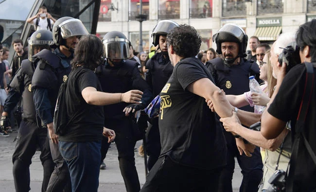 Protesters confront Spanish national police officers during a demonstration at Puerta del Sol square in Madrid on Sunday in support of the right to hold a referendum on self-determination in Catalonia and against repression. Several left-wing Spanish politicians today demanded Prime Minister Mariano Rajoy resign after police used force to block voting in a banned independence referendum in Catalonia, injuring dozens of people. (AFP / JAVIER SORIANO)