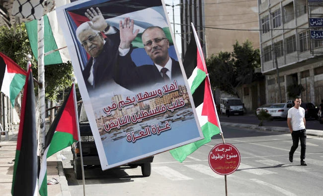 A poster of Palestinian president Mahmoud Abbas and Palestinian Prime minister Rami Hamdallah hangs on a street in Gaza City, on Sunday. (AP)