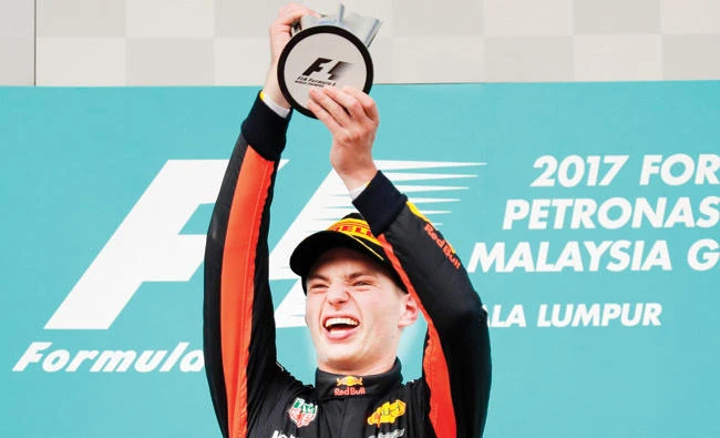 Red Bull driver Max Verstappen of the Netherlands holds his trophy aloft as he celebrates after winning the Malaysian Formula One Grand Prix at the Sepang International Circuit in Sepang, Malaysia, Sunday. (AP)