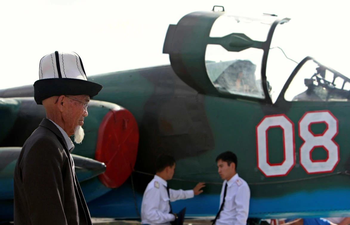 A Kyrgyz man wearing national hat walks past a Russian Sukhoi SU-25 jet during a show dedicated to the 100th anniversary of Russia's Air Force at the Russian air force base in Kant, near Bishkek, Kyrgyzstan August 12, 2012. (File photo by REUTERS)