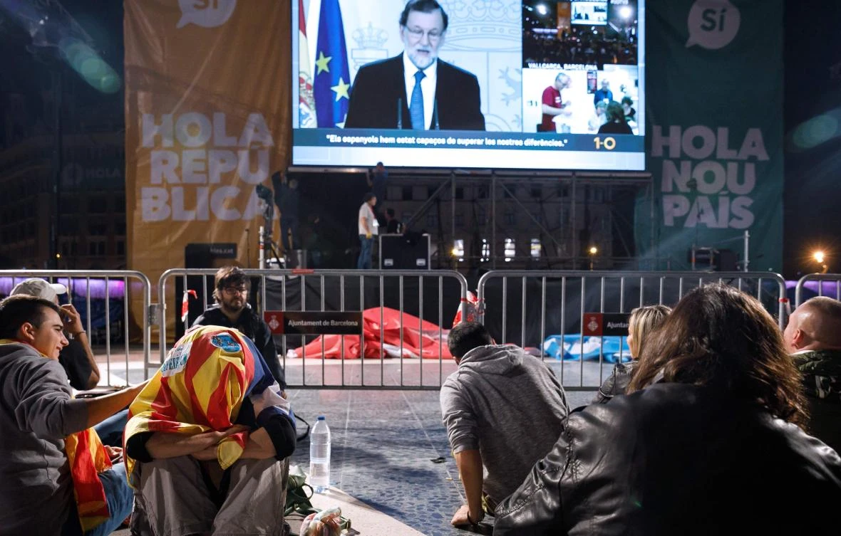 People listen to a speech by Spanish Prime Minister Mariano Rajoy as they gather at Plaza Catalunya in Barcelona to wait for the results of a banned independence referendum after the closing of polling stations on October 1, 2017. (File photo by AFP)