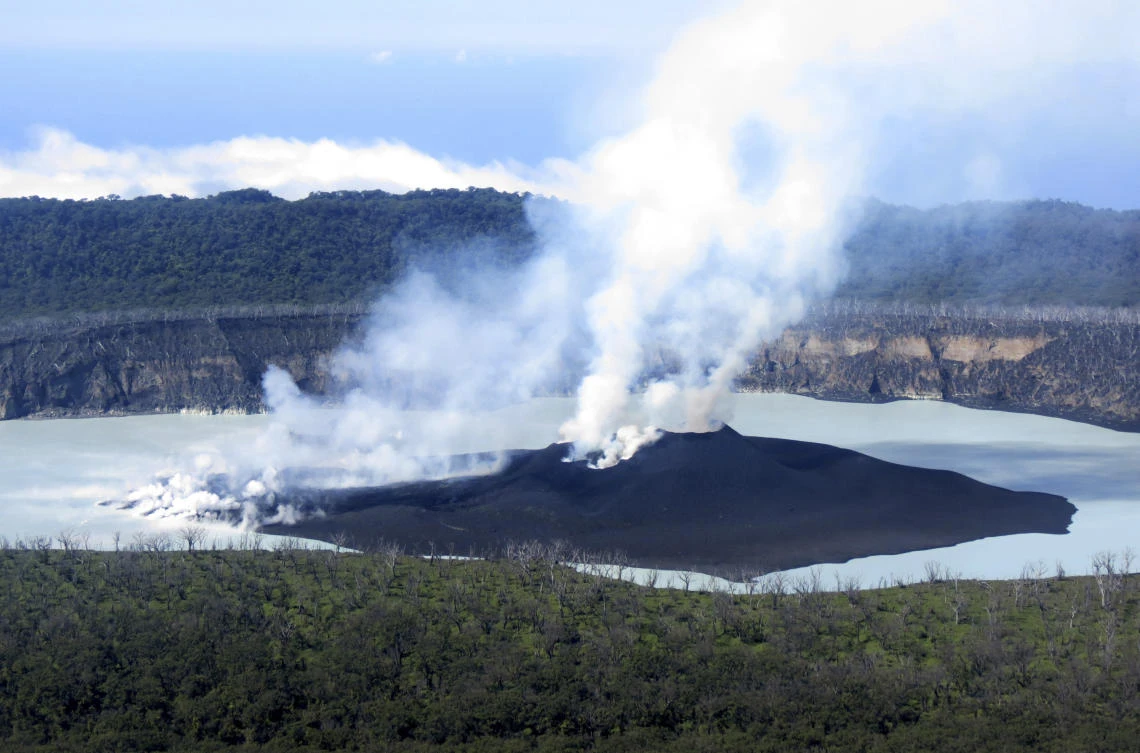 This file photo provided by GeoHazards Divison, Vanuatu Meteorological and GeoHazards Department, shows an aerial view of the volcanic cone that has formed in Lake Vui near the summit of Ambae Island, Vanuatu on October 1, 2017. (GeoHazards Divison, VMGD via AP)